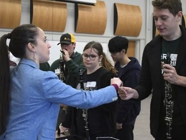 a woman equips students with instruments for brighton music center's clarinet day